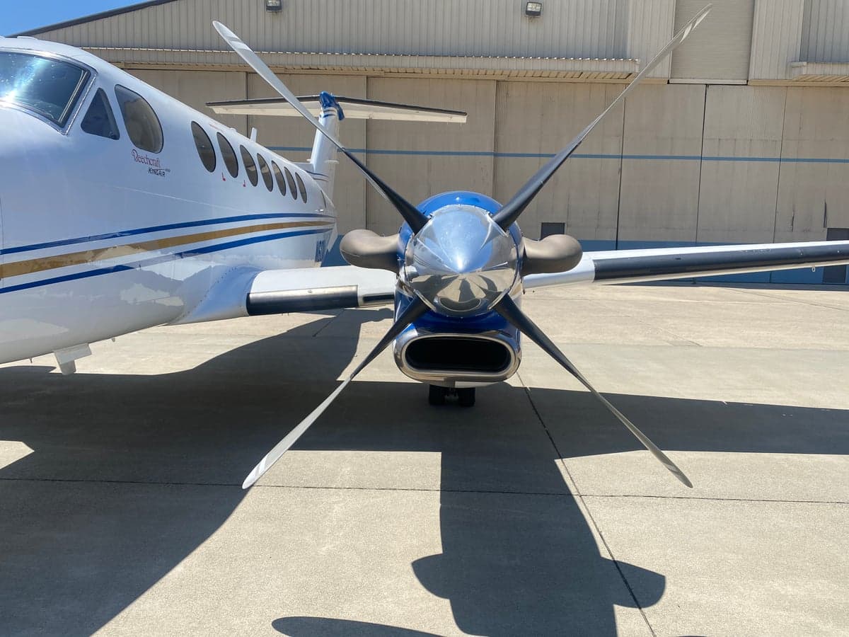 A head-on view of the right engine and propeller of the Beechcraft King Air 350, showing its blue and white paint scheme.