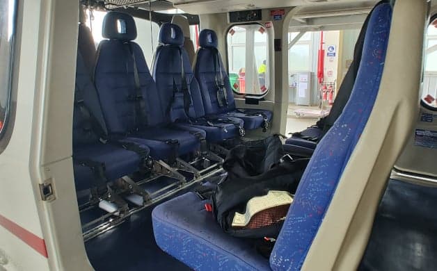 Helicopter interior with blue passenger seats.