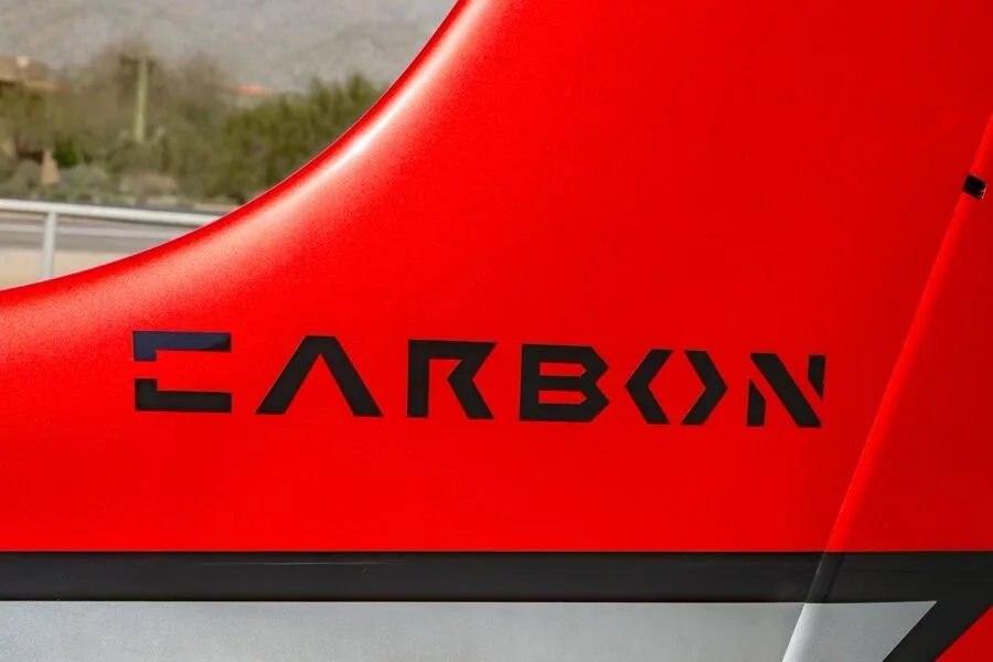 A close-up view of the "CARBON" branding on the red tail of the aircraft.