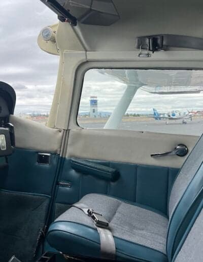 View from inside the aircraft cabin, looking out at the airport control tower.