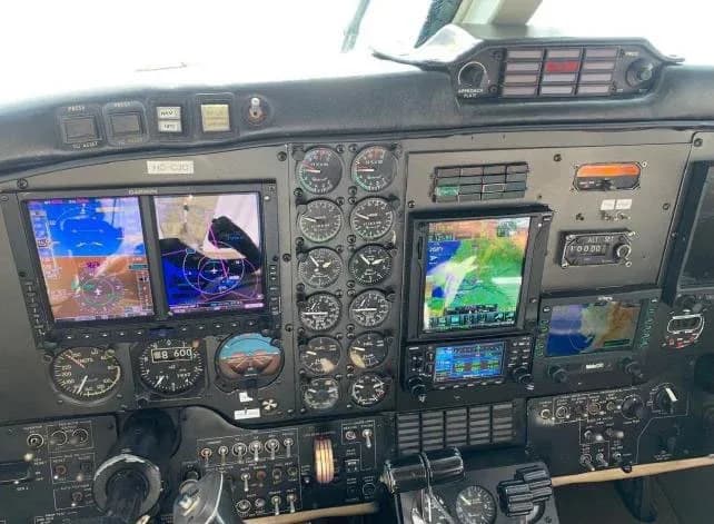 The cockpit instrument panel of an aircraft with multiple analog gauges and digital displays.