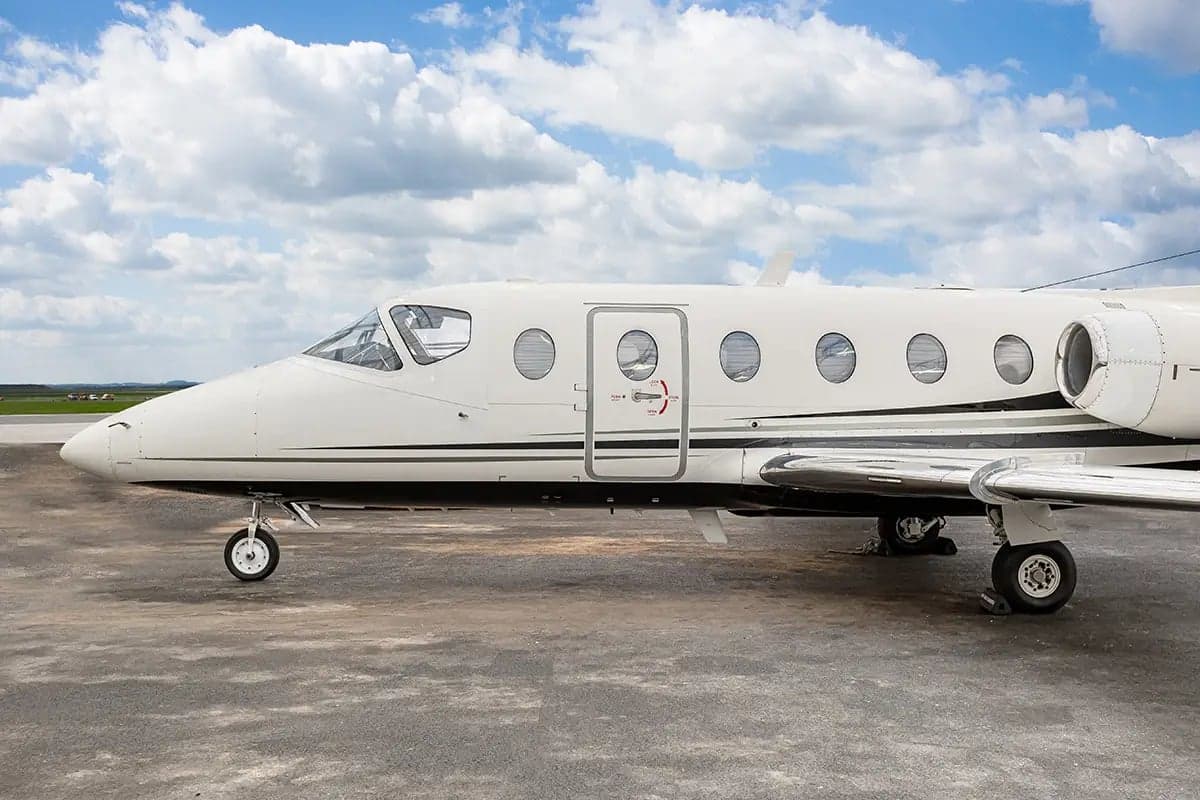Close-up of the Nextant 400XT aircraft with registration OK-ESC showing the fuselage and door.