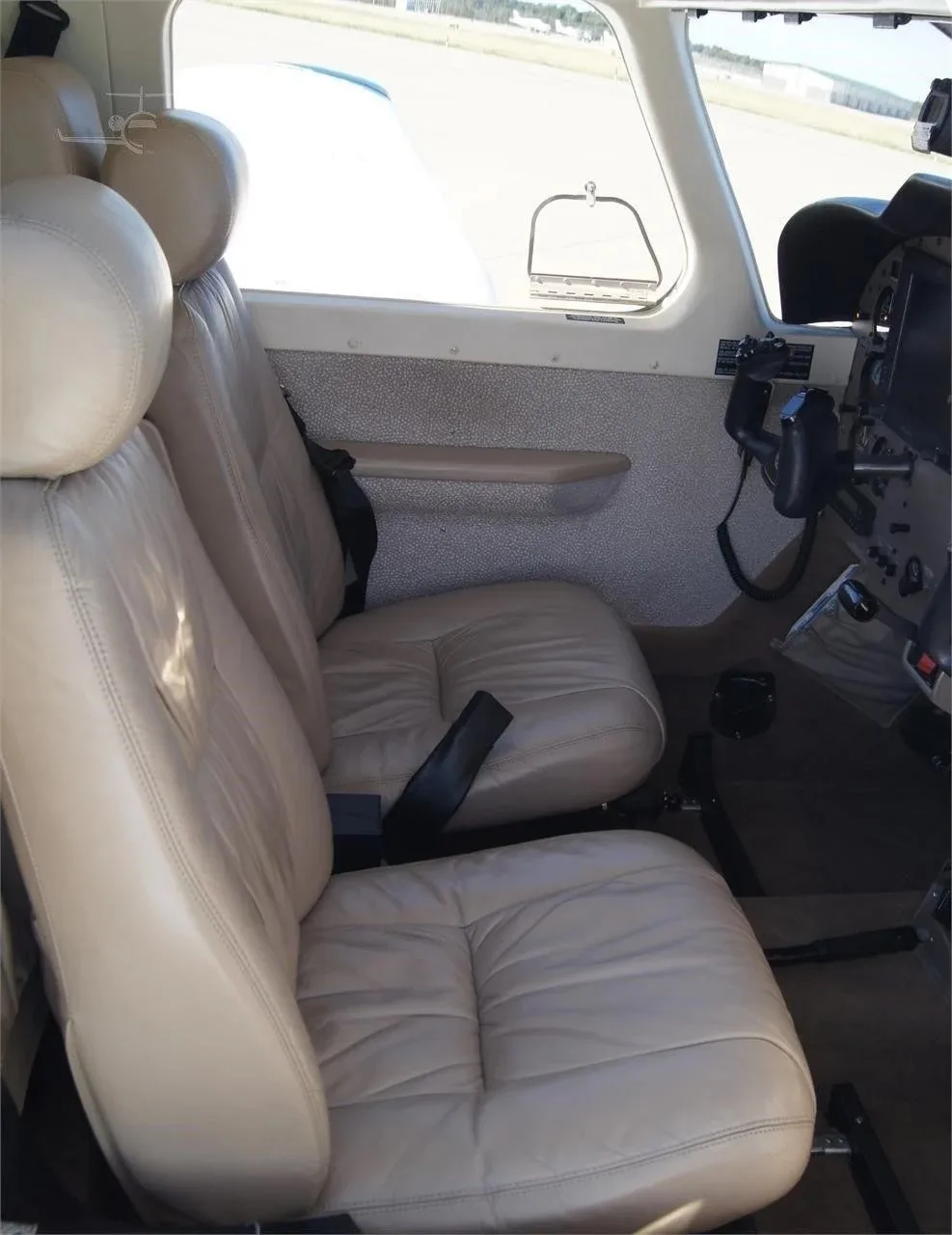 A view of the light tan leather pilot and co-pilot seats inside the Piper 6XT cabin.