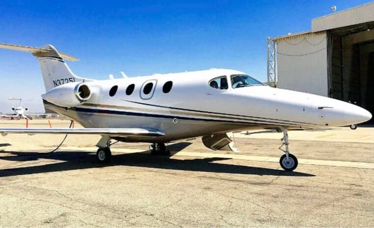 Side view of a white and silver jet with registration N3725L on the tail, parked on the tarmac.