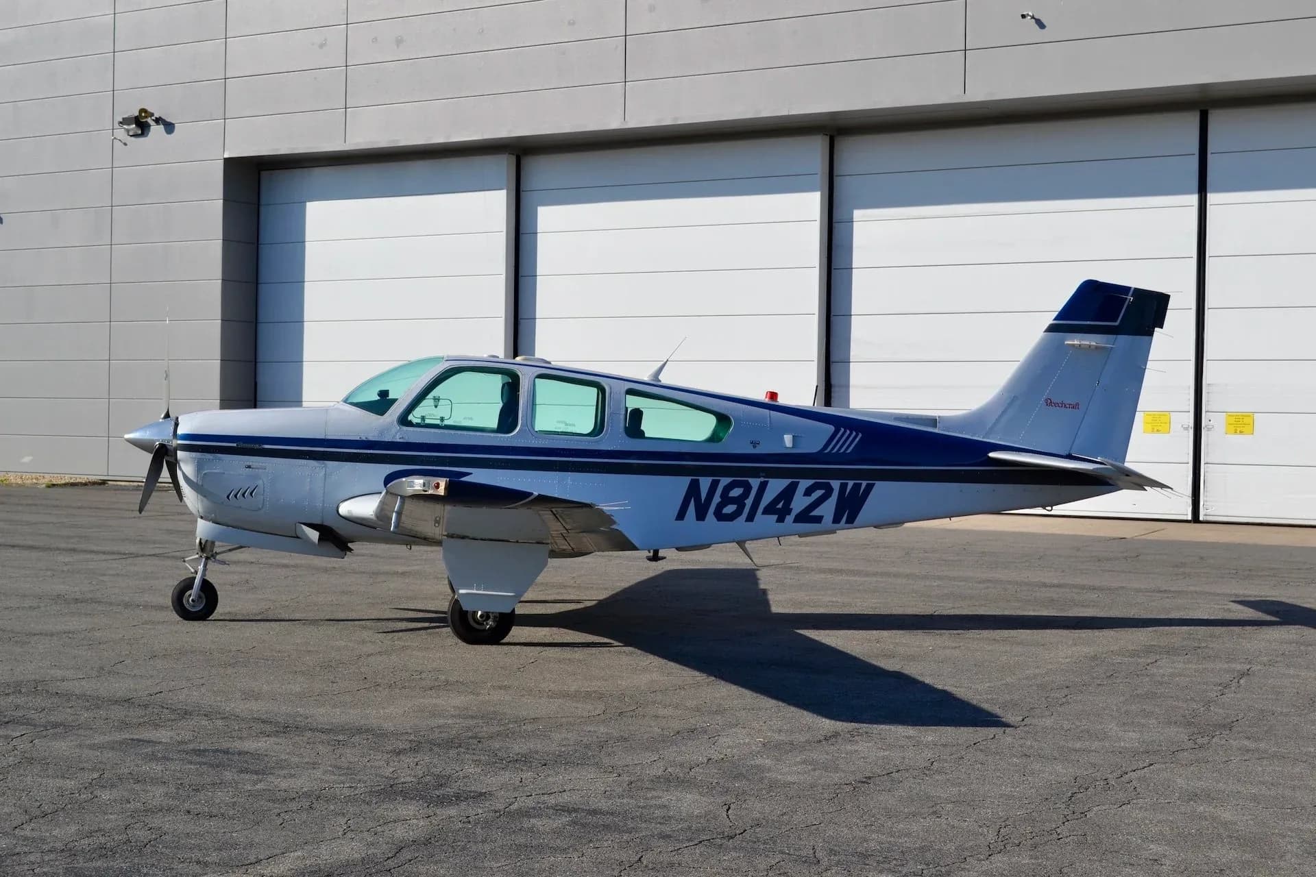 Side view of the Beechcraft Bonanza N8142W parked on the tarmac.