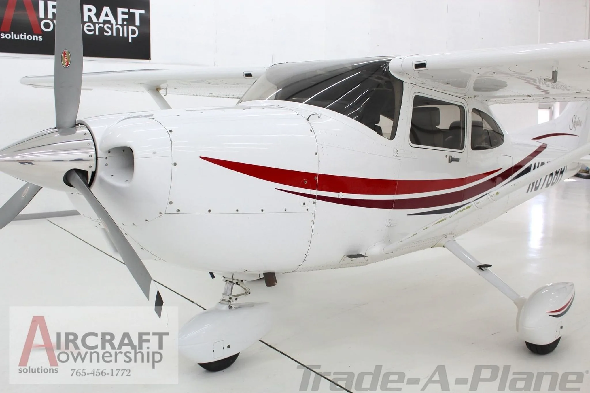 A close-up front-right view of the white Cessna Skylane N6768R, showing the propeller and nose.