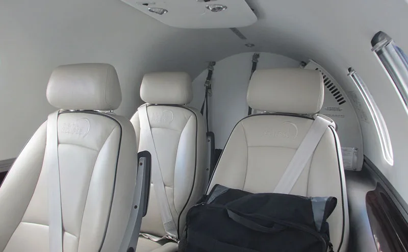 Interior view of the Eclipse jet cabin with cream-colored leather seats.