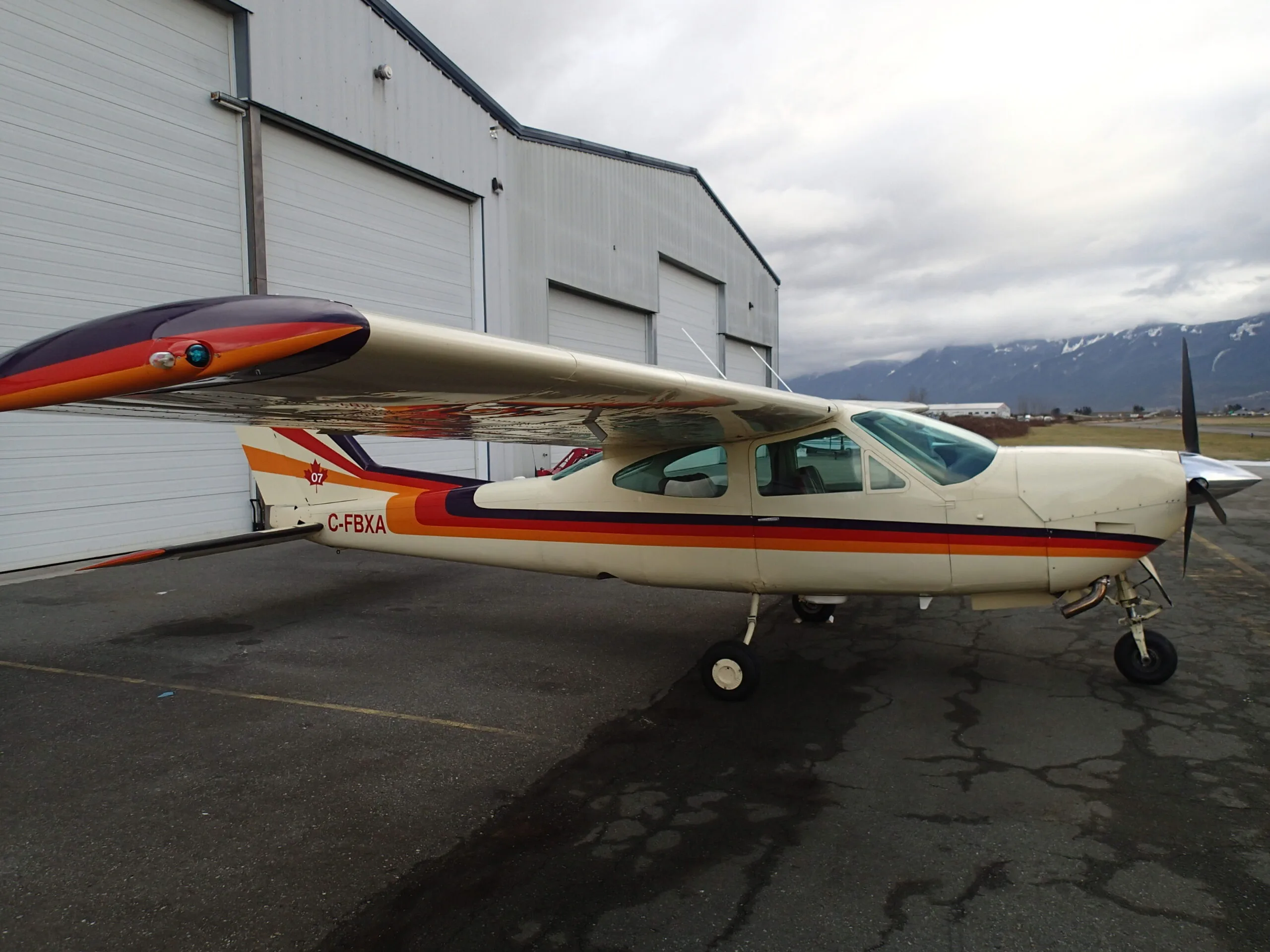 Side view of Cessna Cardinal RG C-FBXA parked on the tarmac.