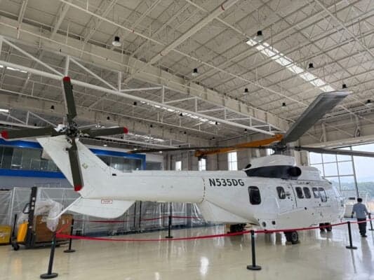 A Eurocopter AS332 Super Puma helicopter with registration N535DG is parked inside a hangar, viewed from the rear.