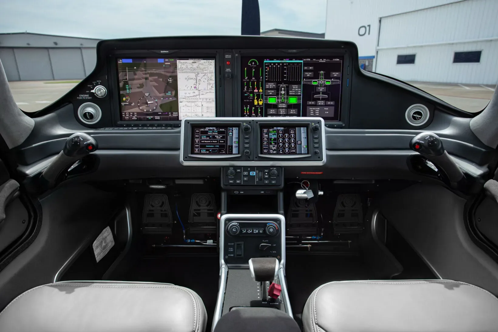 The modern digital instrument panel of the aircraft cockpit, featuring multiple screens and controls.
