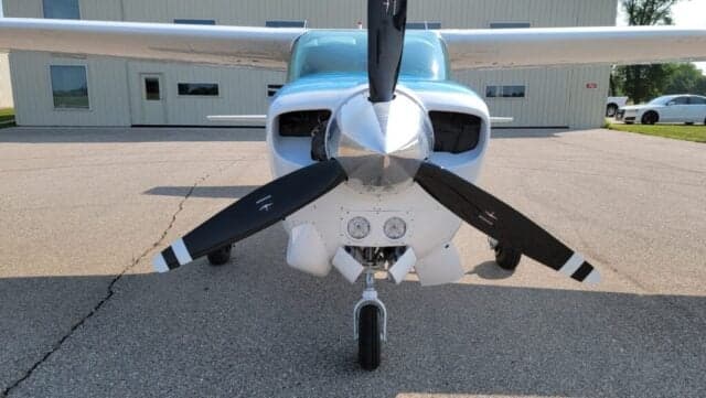 View of the wing and fuselage of a Cessna Centurion aircraft with a blue and white paint scheme.