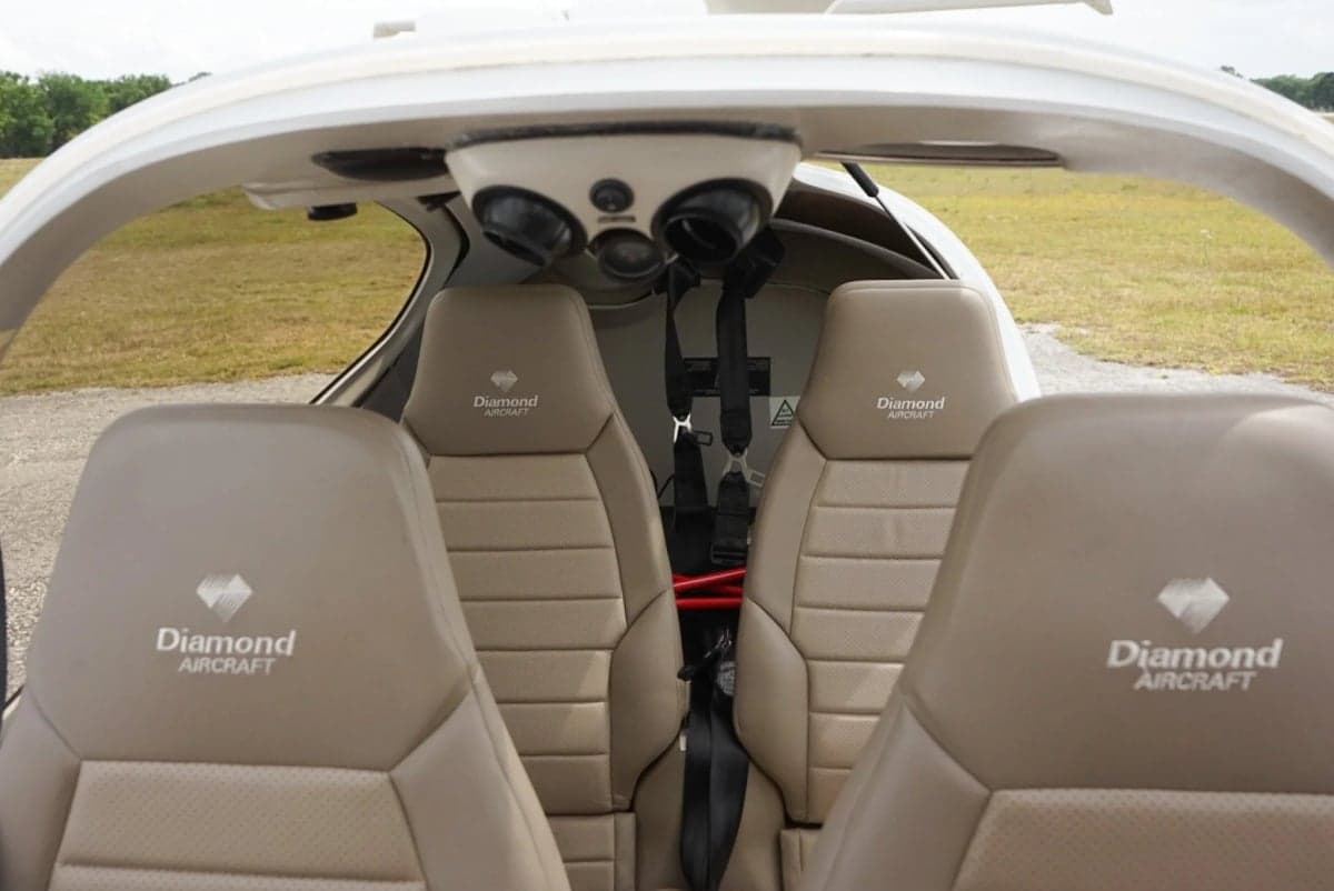 Rear view of the aircraft's interior showing the seats and seatbelts.