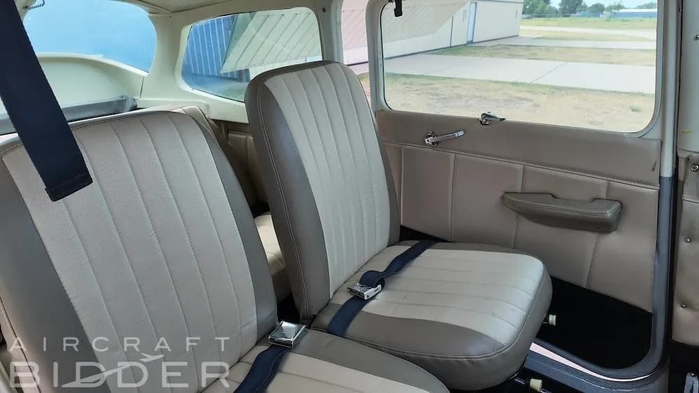 The tan and cream-colored interior cabin seats of a Cessna 172 aircraft.