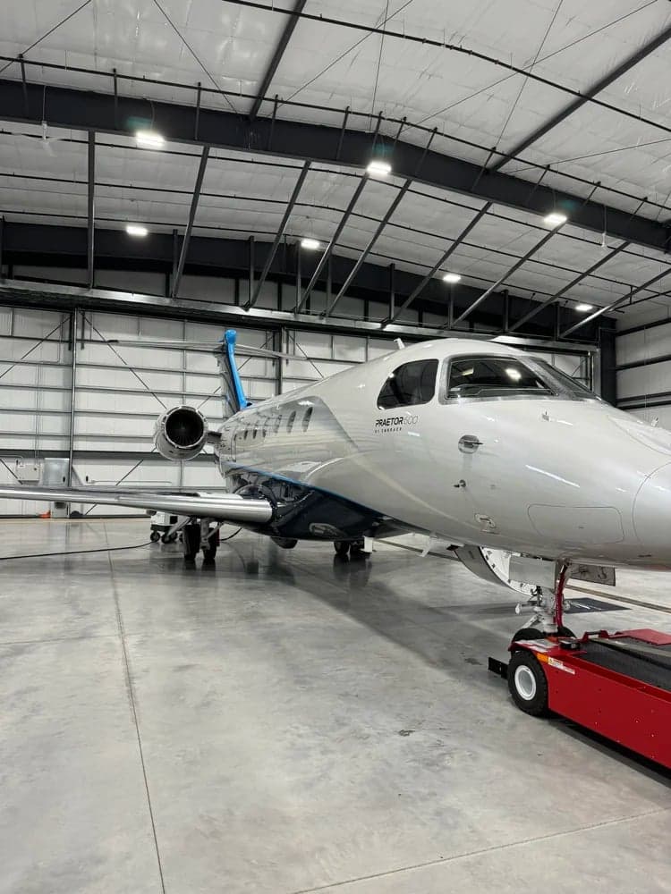 N602EE Praetor 600 aircraft in a hangar, front quarter view.