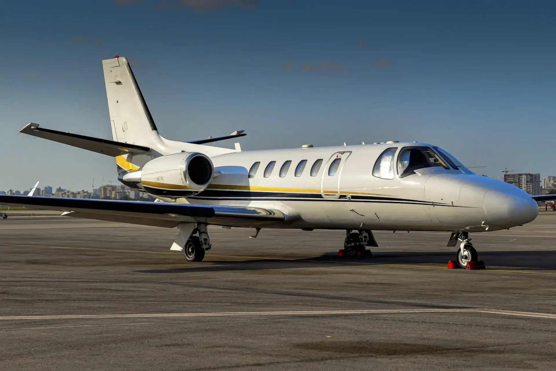 A white and grey jet aircraft is parked on the tarmac.