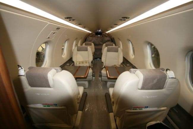 Interior view of the Pilatus PC-12 cabin with leather seats and tables.