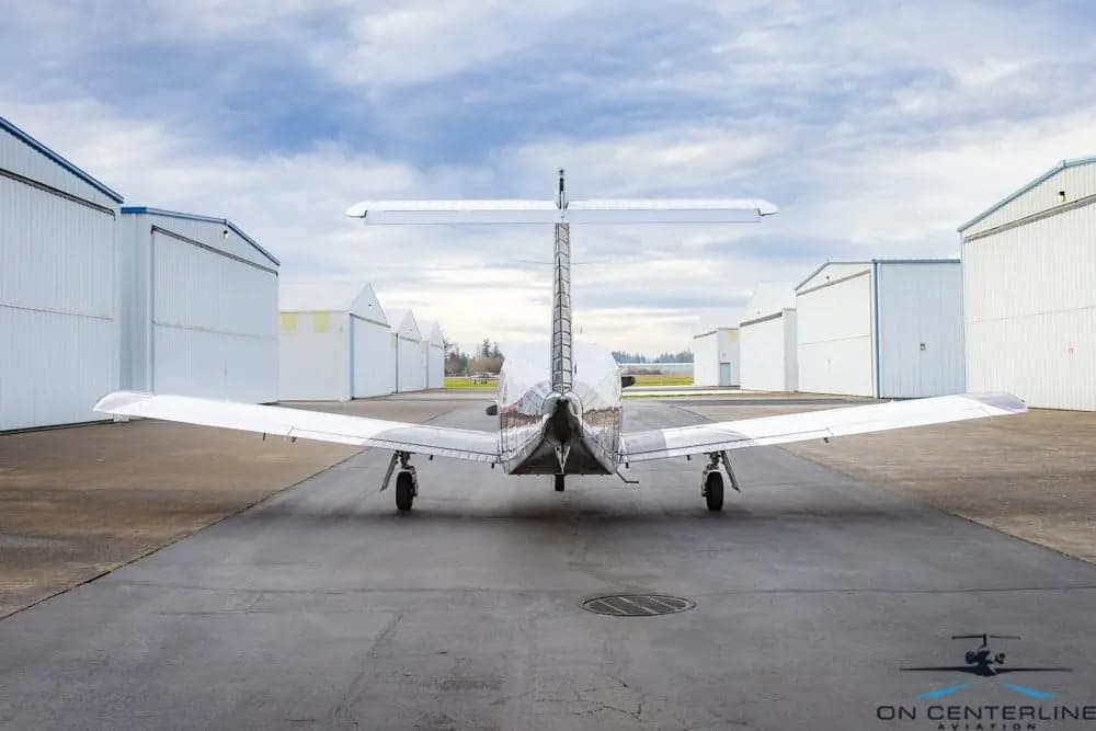 Rear view of a Piper PA-32R-301 Saratoga SP, registration N541MV, parked on the tarmac.