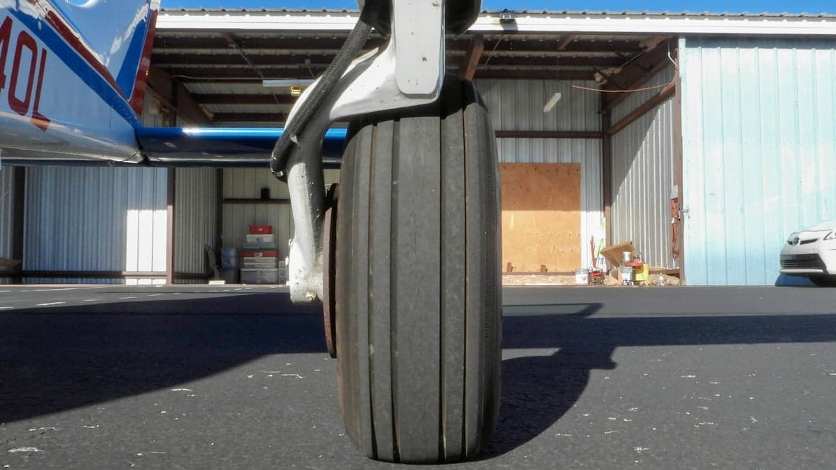 Close-up of the landing gear and tire of a Piper PA-28-140 Cherokee.