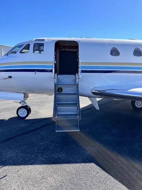 A close-up view of the open airstair door and front section of the N700JC business jet.