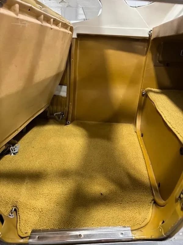 The rear cabin area of the aircraft has mustard yellow carpet and brown side panels.
