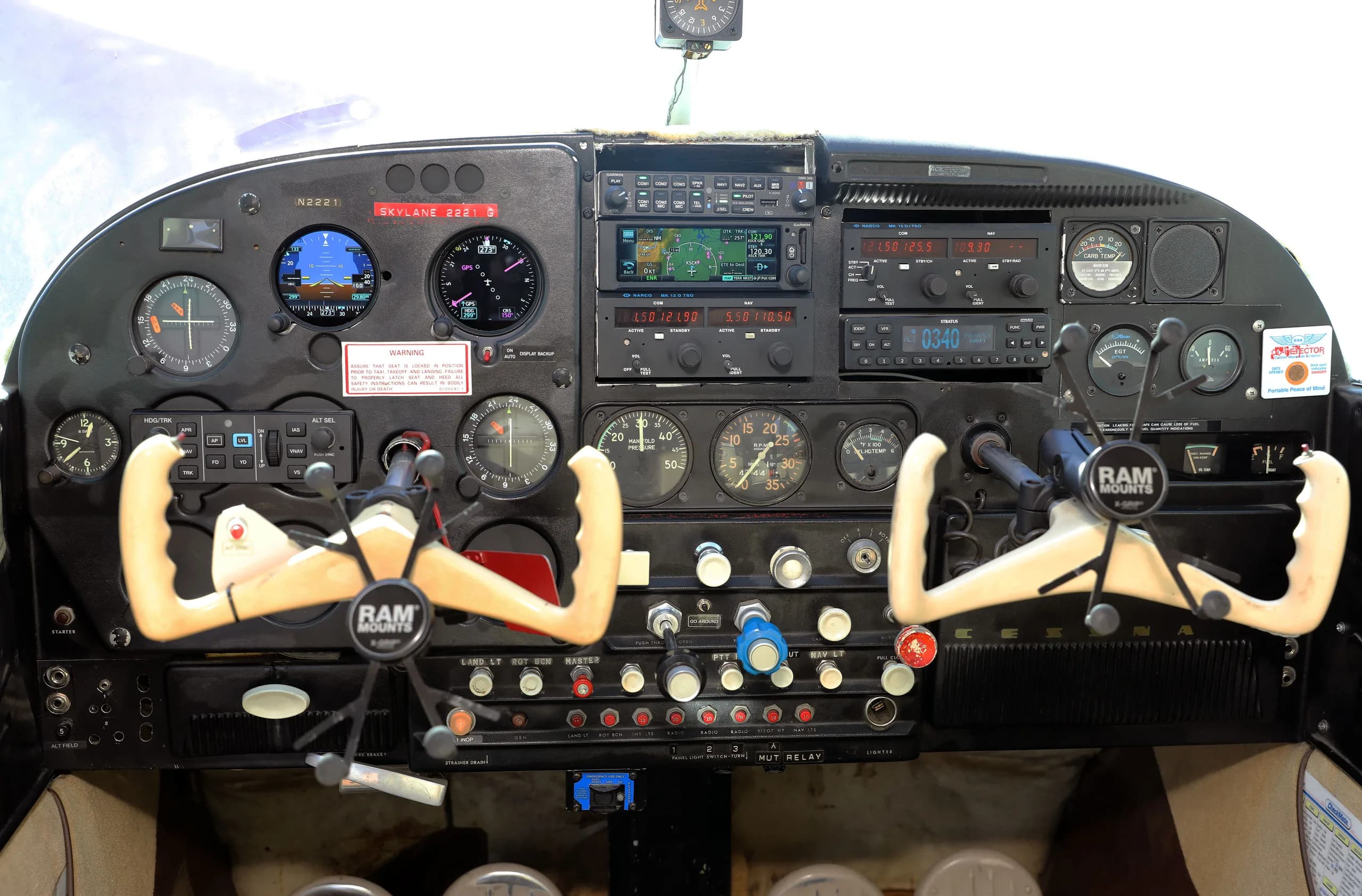 The cockpit instrument panel of a Cessna 182 Skylane N2221 with dual yokes and modern avionics.
