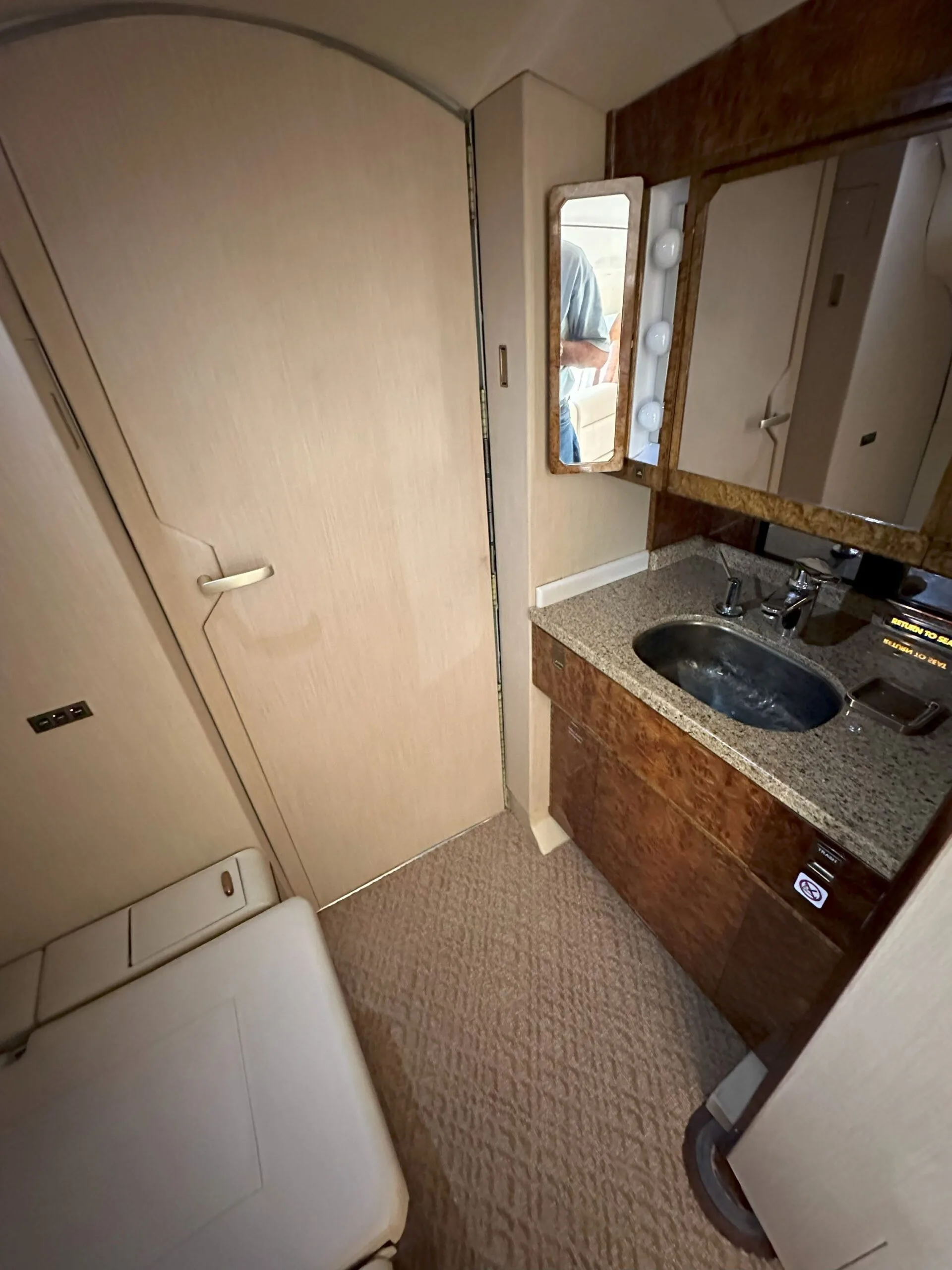 Aircraft lavatory with sink and mirror.