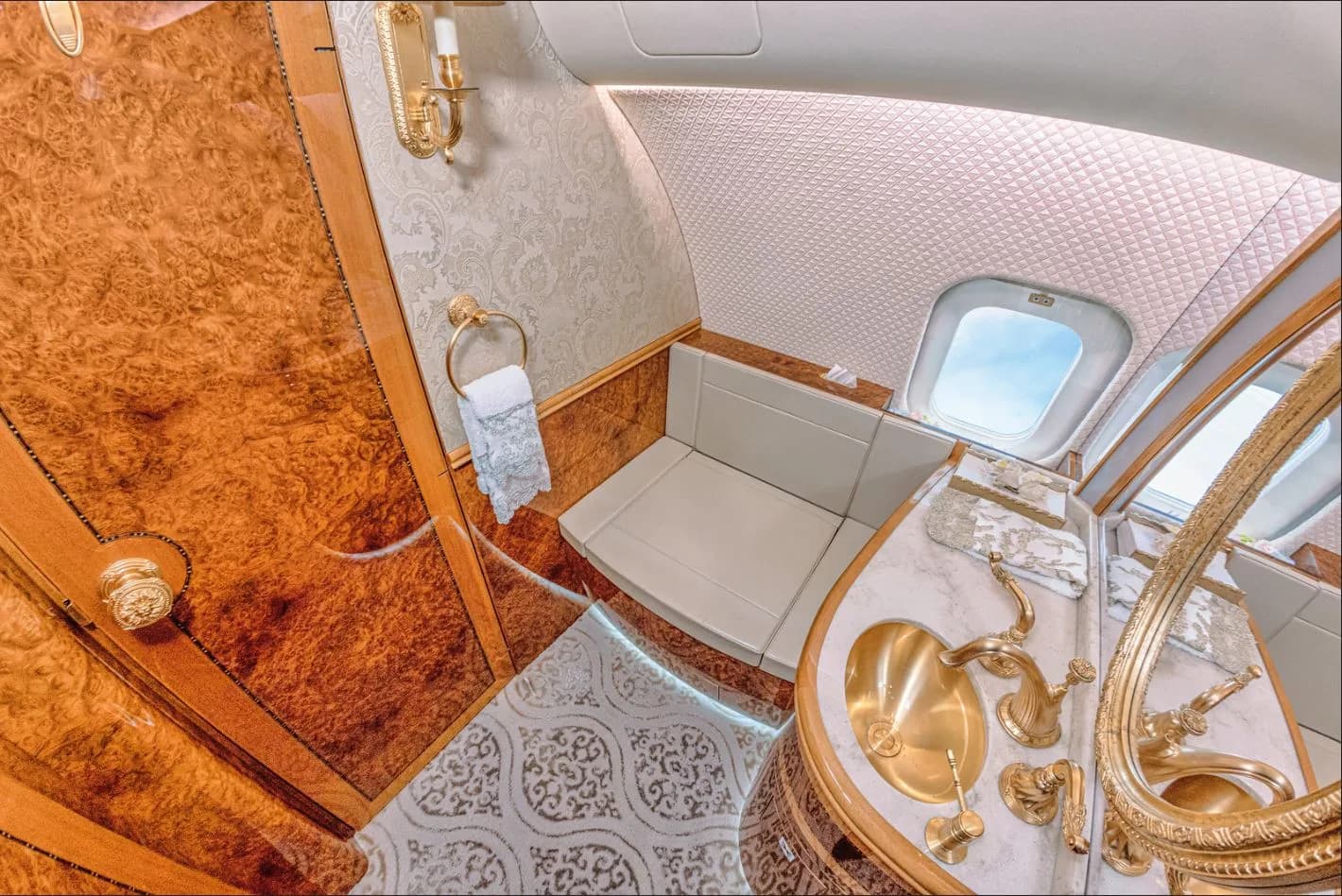 View of the aircraft's lavatory with gold fixtures and wood accents.
