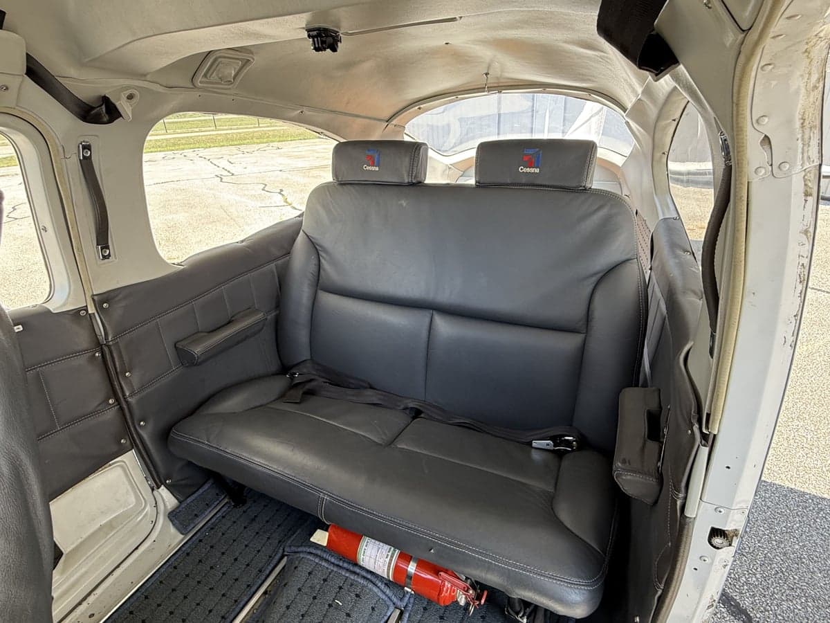Rear cabin seats of the aircraft with black leather upholstery.