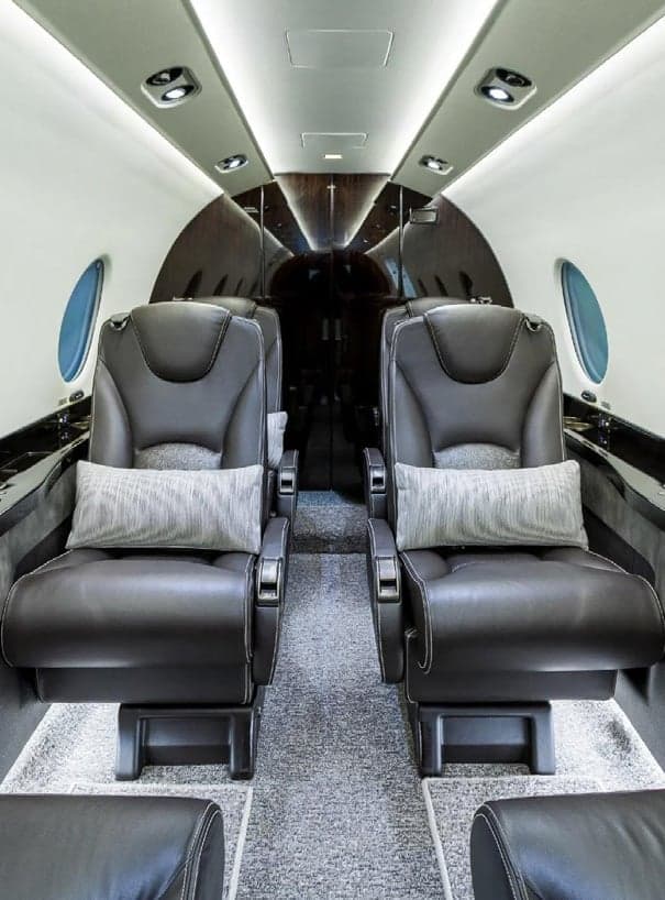 Interior view of the aircraft cabin with leather seats and pillows.