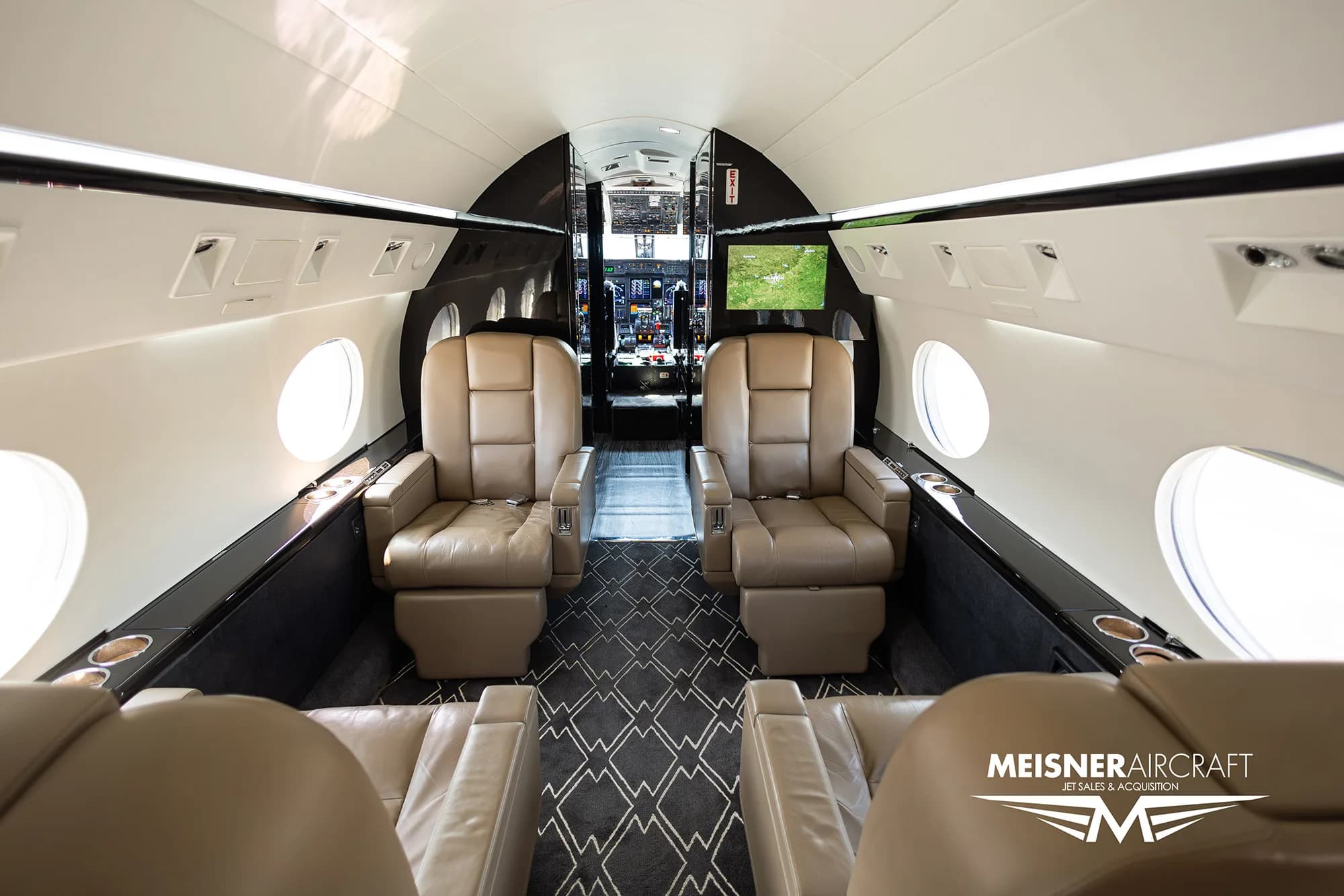 Interior of the aircraft cabin with leather seats and patterned carpet.