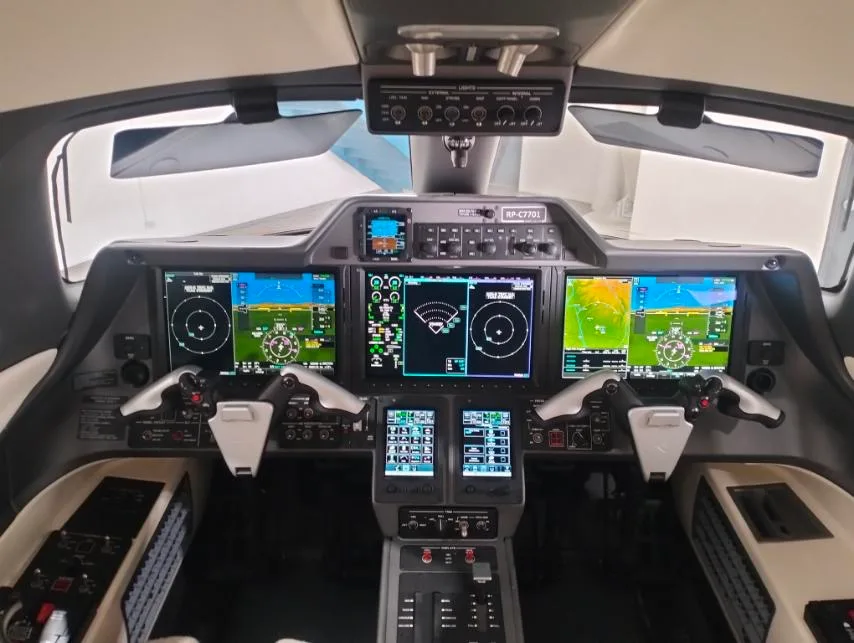 The advanced glass cockpit of a business jet, displaying multiple digital screens and controls.