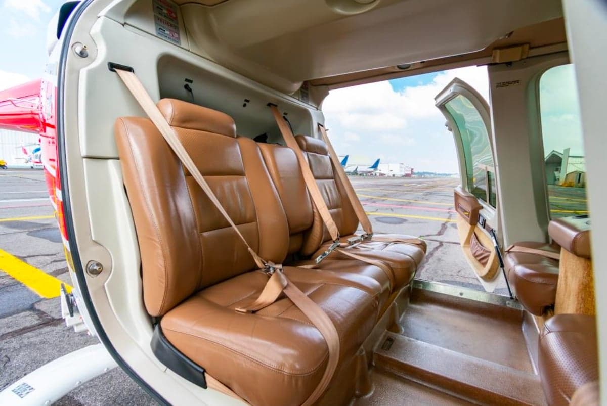 View of the rear brown leather seats in the cabin of the helicopter.
