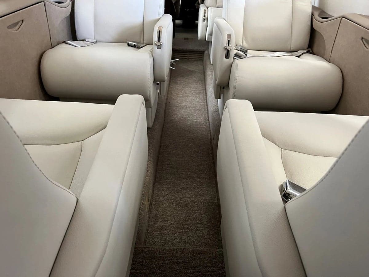 View down the aisle of the aircraft cabin, showing the leather seats.
