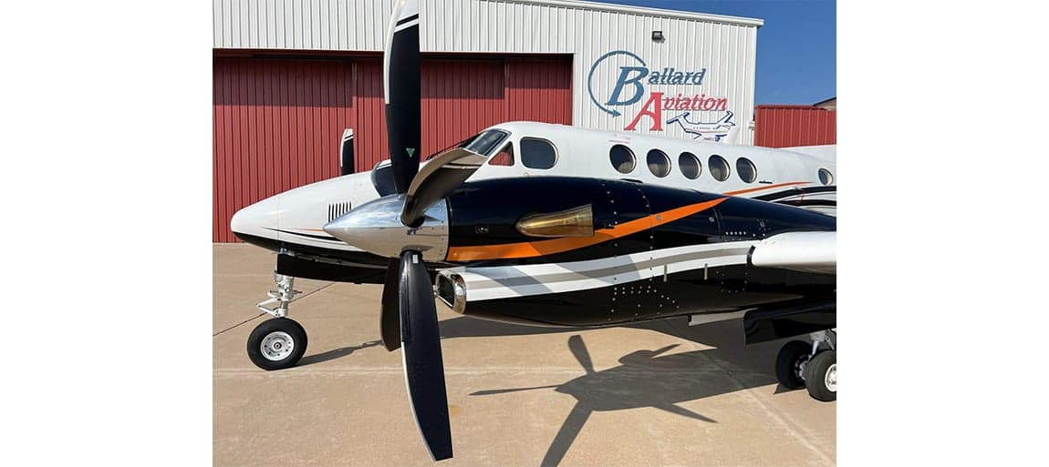 Close up of the King Air aircraft showing the propeller and paint scheme.