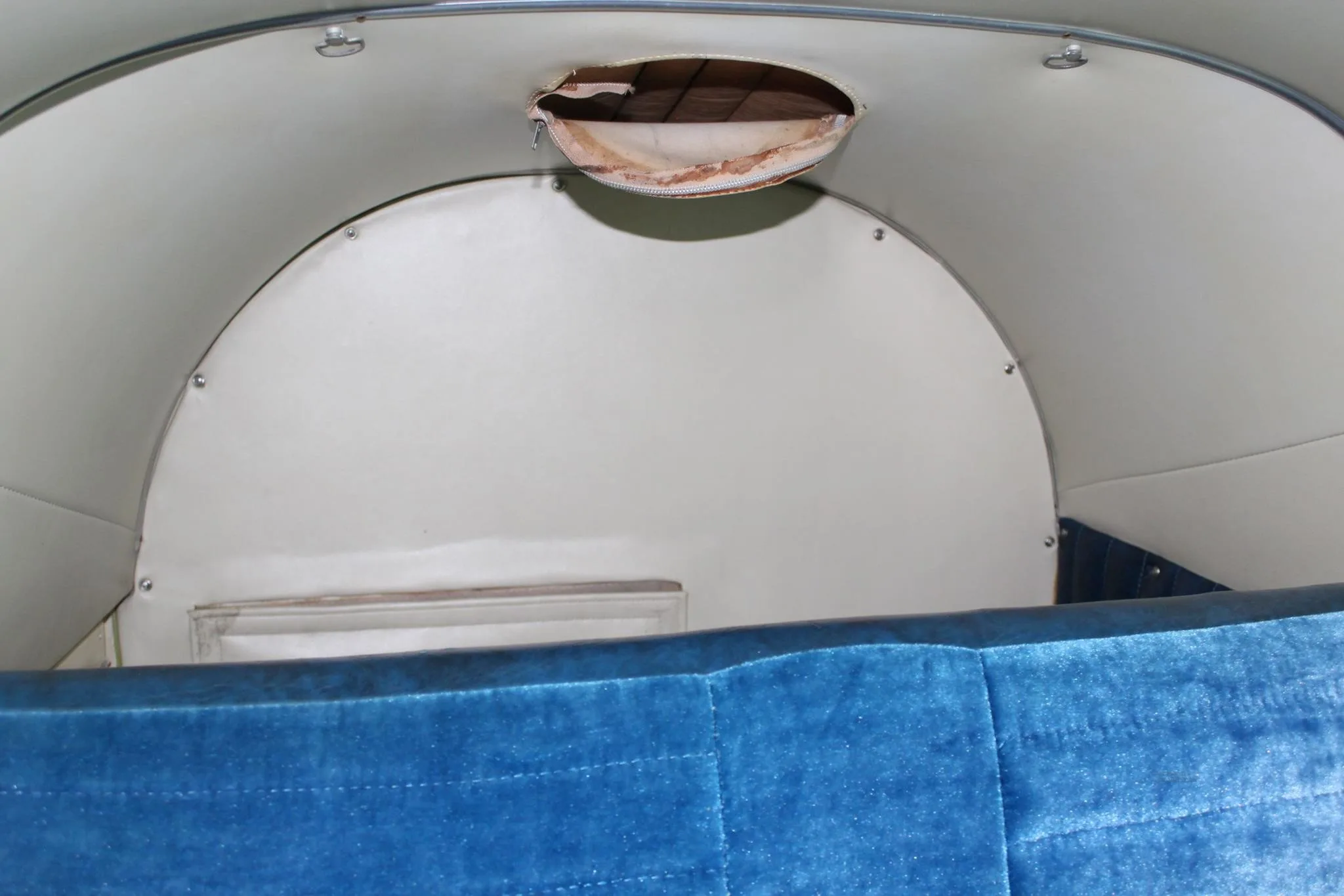 Interior view of the aircraft cabin ceiling with a small opening.