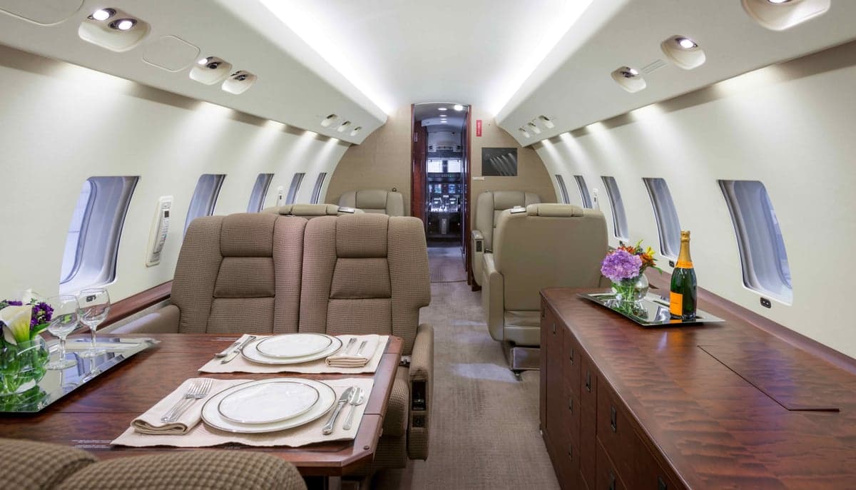 Interior view of the aircraft cabin with a dining table and seating.