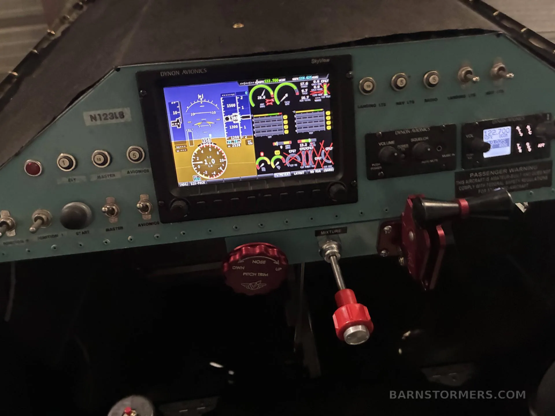The cockpit instrument panel of a light blue aircraft, featuring a Dynon Avionics SkyView display and various switches and controls.