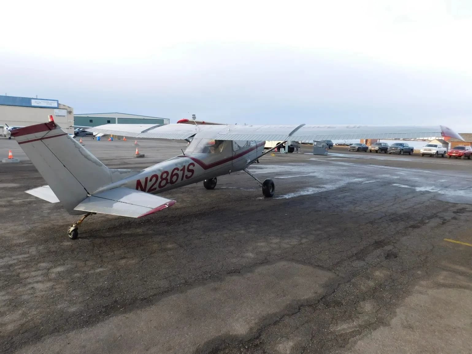 A silver and red single-engine propeller aircraft (N2861S) parked on a tarmac, viewed from the rear.