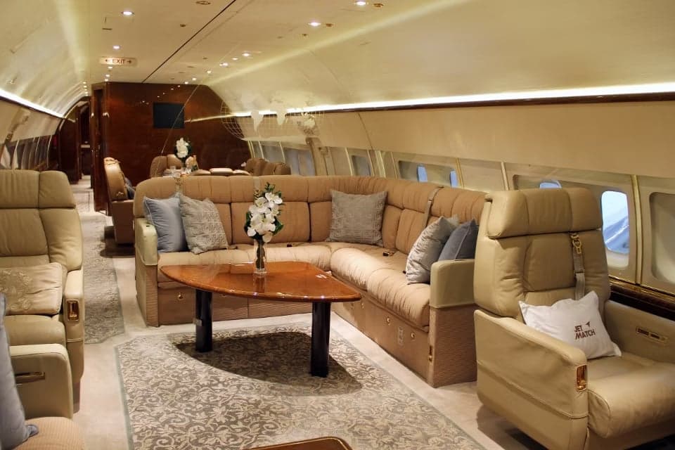 A luxurious aircraft interior with a large sofa and comfortable seating.
