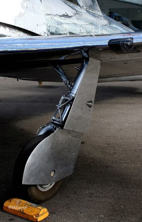 Close-up of the cockpit and wing of a polished aircraft.