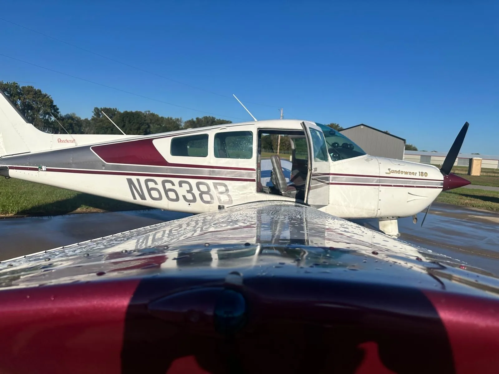 Close-up side view of a white and maroon Beechcraft Sundowner 180, showing the N6638B registration and wet wing.