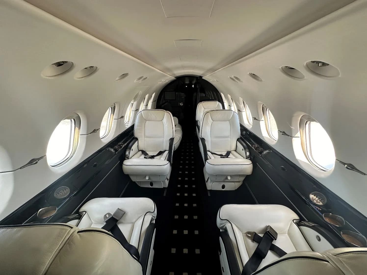 Interior view of the Hawker 400XP cabin with white leather seats.