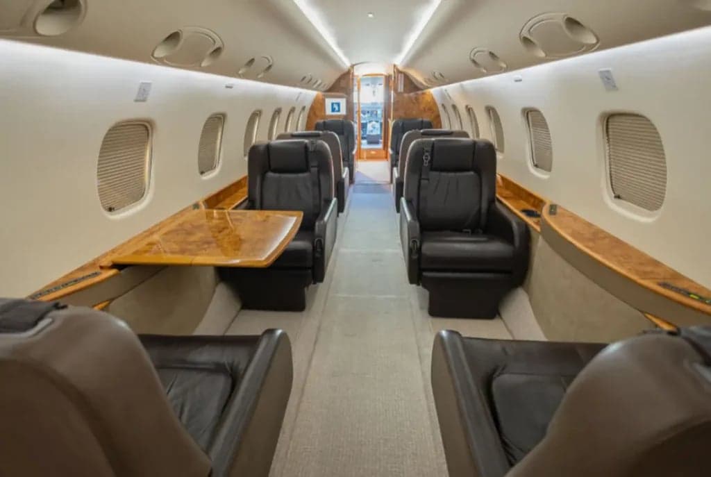 View of the interior cabin with leather seats and wood accents.