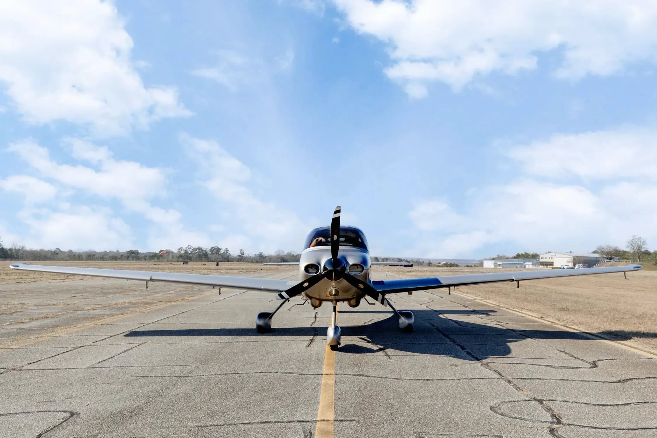 A head-on view of the Cirrus SR20 GTS aircraft with N667MT registration, centered on an airfield runway.