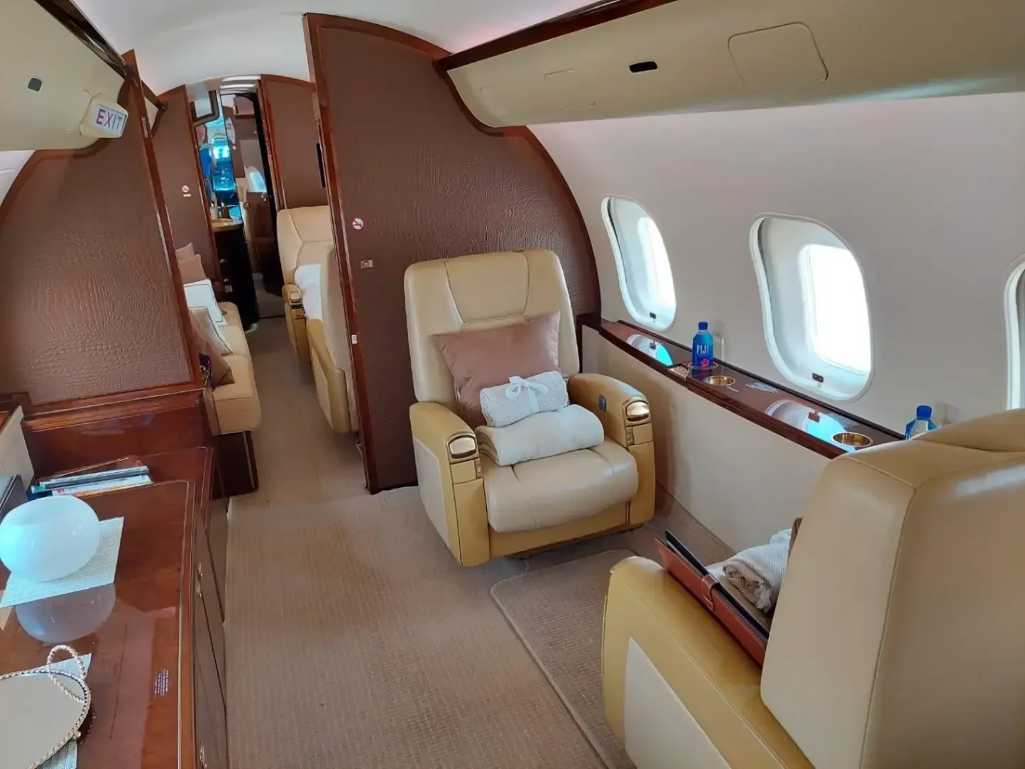 The interior of a Bombardier Global Express business jet showing the seating arrangement and amenities.