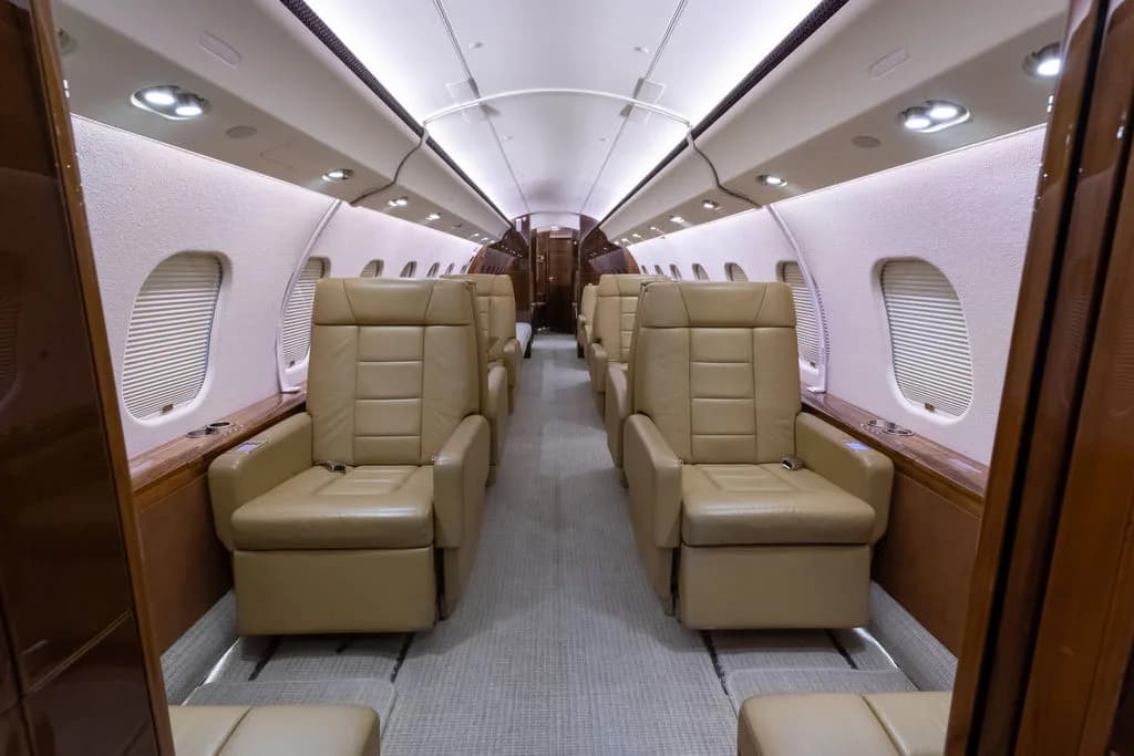 The aircraft's interior features tan leather seats and a neutral carpet.