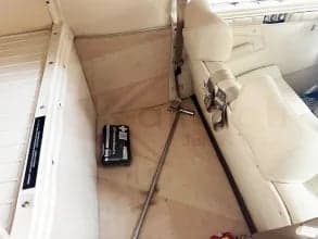 Interior view of the aircraft showing storage space and cream-colored upholstery.