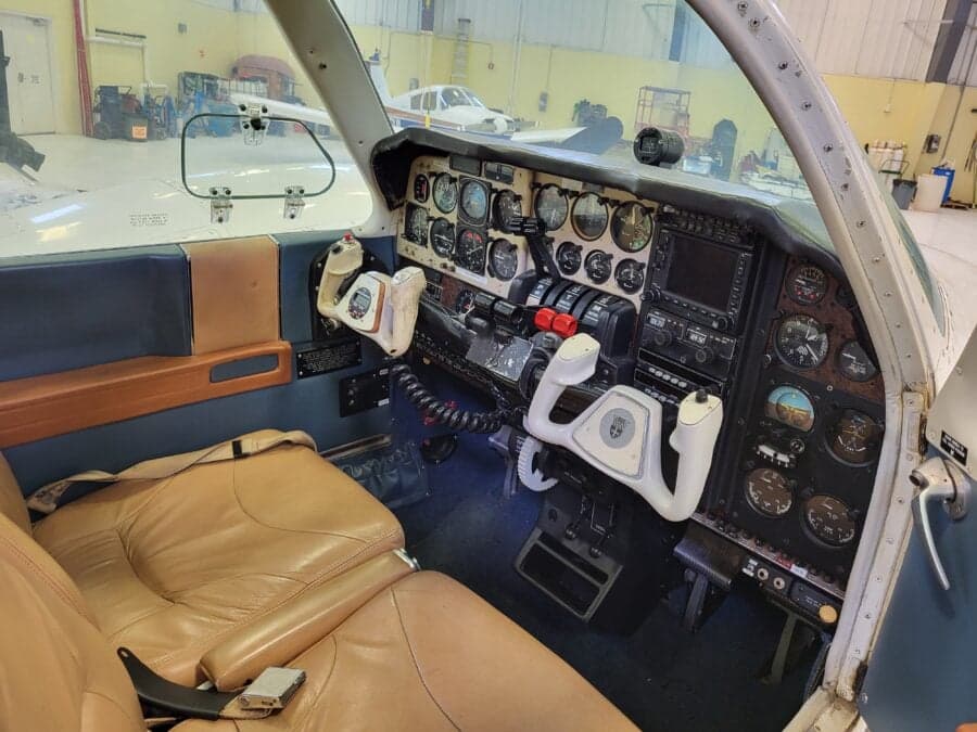 View of the cockpit showing the instrument panel, controls, and seats.