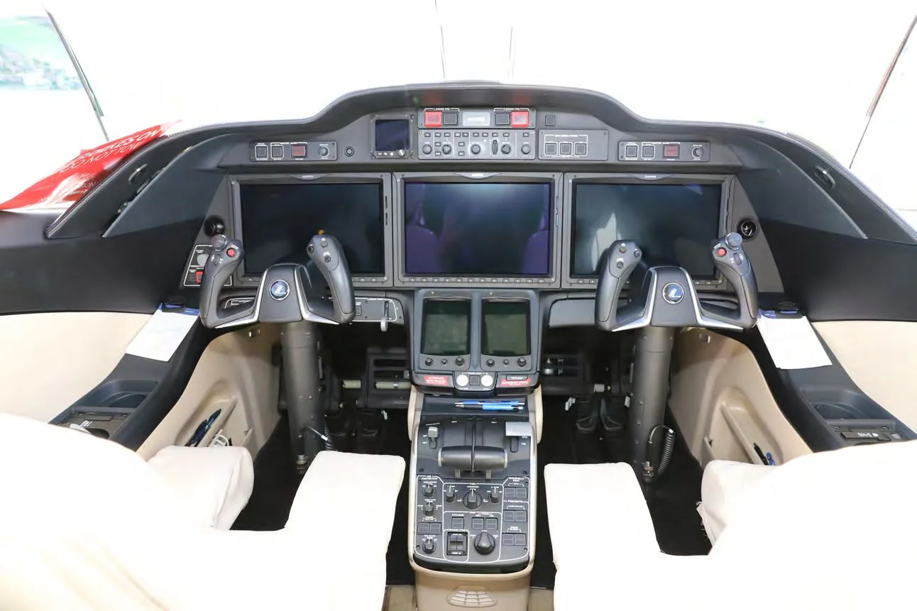 The cockpit of a HondaJet Elite S, showing the instrument panel with three large displays and dual yokes.