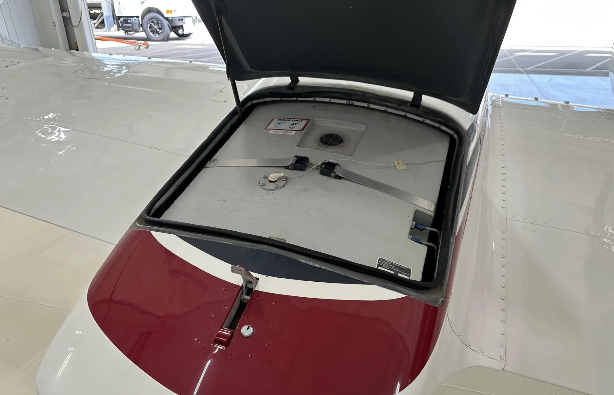 A close-up view of an open fuel tank compartment on the wing of the aircraft.